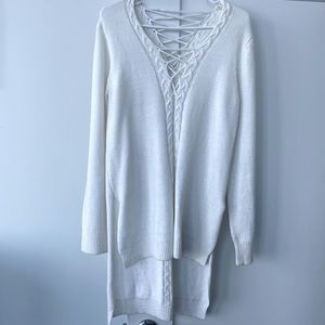 Long white sweater with details on the front and back.